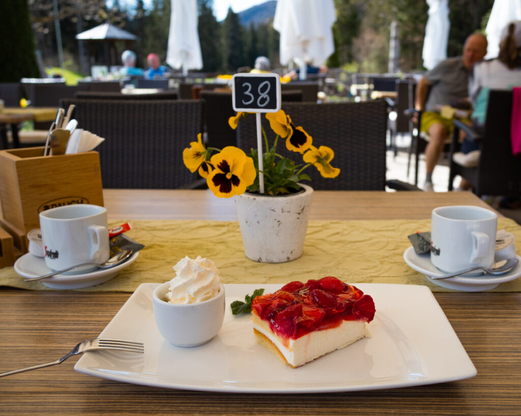 Kaffee und Kuchen mit Sahne auf der Sonnenterrasse des Clubrestaurant des Kaiserwinkl Golf Kössen - Lärchenhof.